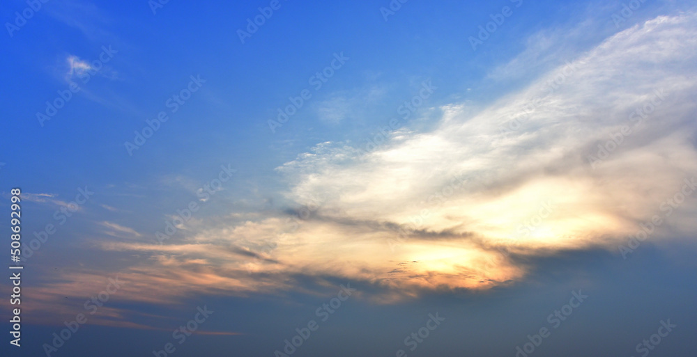 Dramatic sky background, Sunset shine behind clouds with blue sky background
