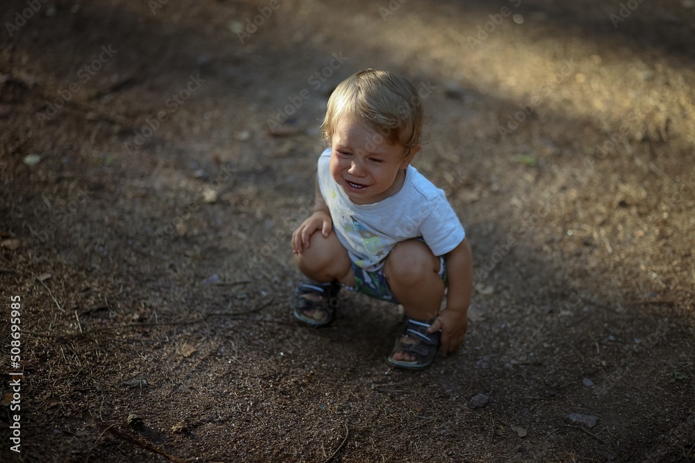 cute little caucasian boy sitting on ground and crying cute little caucasian boy sitting on ground and crying