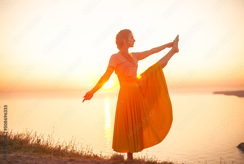 Young woman engaged in yoga in nature with view and warm light of sunset, makes poses enjoy the meditation, balance and sunrise Young woman engaged in yoga in nature with view and warm light of sunset, makes poses enjoy the meditation, balance and sunrise