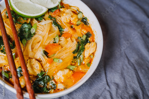 Thai red curry noodle soup with chicken in a bowl