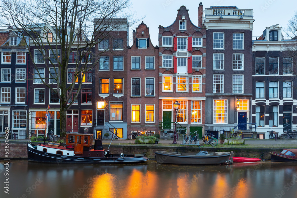 Beautiful old houses on the city waterfront of Amsterdam at sunset. Beautiful old houses on the city waterfront of Amsterdam at sunset.