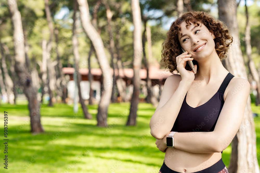 Cute redhead woman wearing casual clothes standing on city park, outdoor talking on mobile phone with friends or boyfriend with smiles. Cute redhead woman wearing casual clothes standing on city park, outdoor talking on mobile phone with friends or boyfriend with smiles.