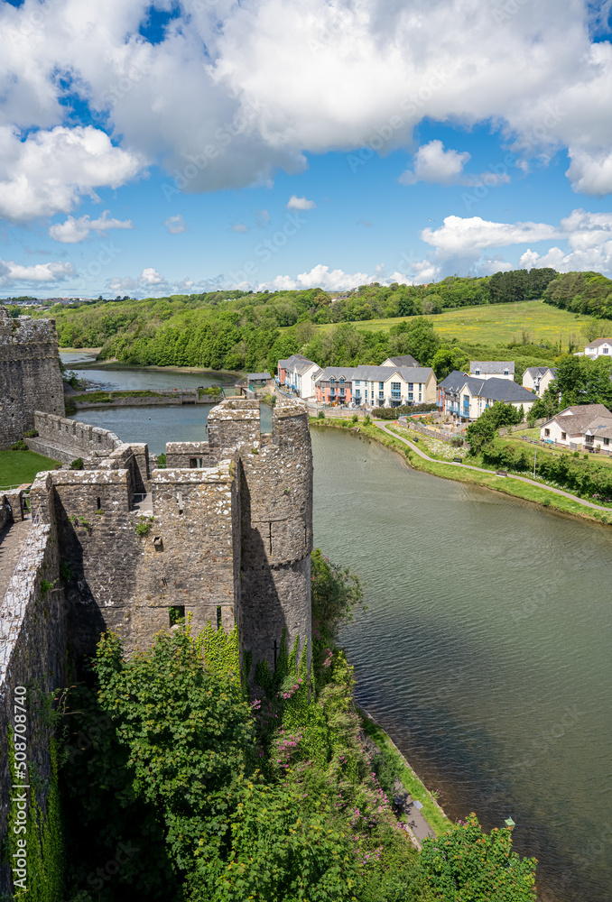 view from the top of 80 foot high keep at the stunning Pembroke Castle, looking across Pembroke river, blue sky background