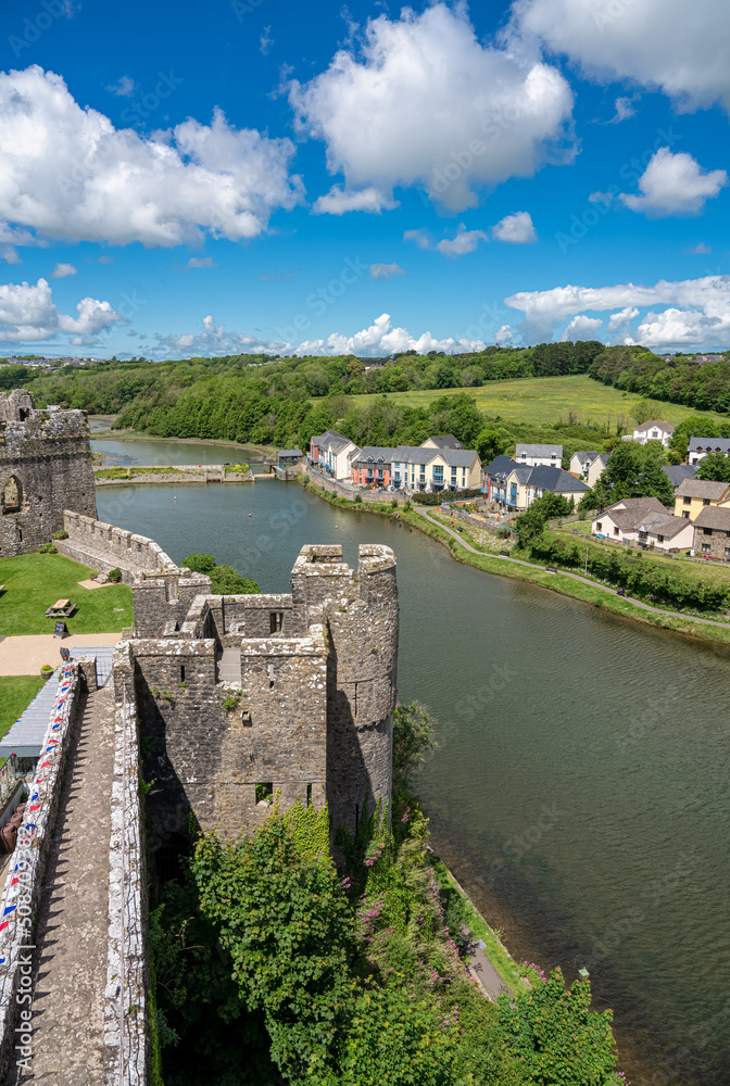 view from the top of 80 foot high keep at the stunning Pembroke Castle, looking across Pembroke river, blue sky background