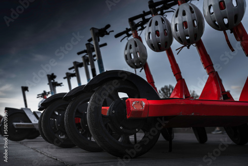 Calgary Alberta Canada, May 22 2022: Dark moody lighting of electric scooted line-up in a designated parking stall on a popular sidewalk near Princess Island Park.