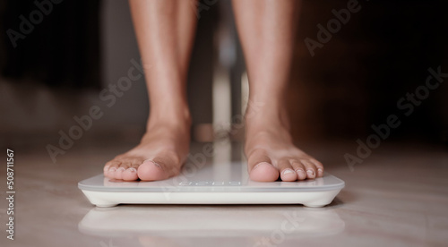 Woman on scales measure weight. Female dieting checking BMI weight loss.