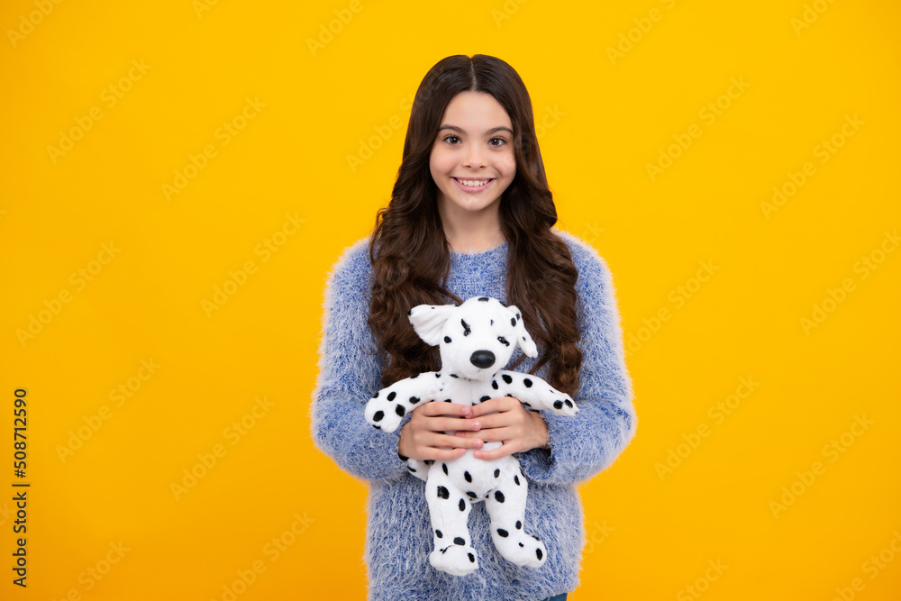 Teenager girl 12, 13, 14 year old hold soft toy for birthday on yellow background. Kid with her toys. Happy teenager, positive and smiling emotions of teen girl. Teenager girl 12, 13, 14 year old hold soft toy for birthday on yellow background. Kid with her toys. Happy teenager, positive and smiling emotions of teen girl.