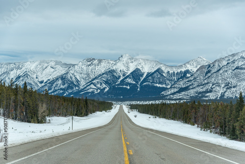 Road trip views in northern Canada during the start of winter with incredible snow capped mountains in the distance. 