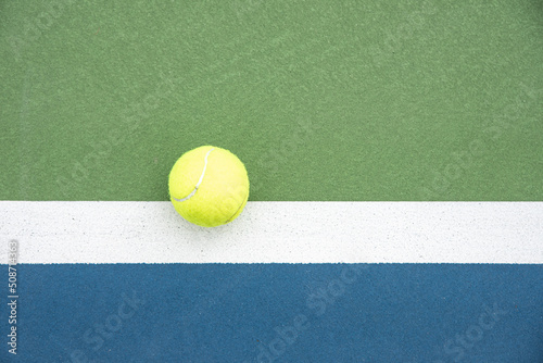 Fototapeta Top view of a tennis ball hitting outside the line of the doubles sideline on a court