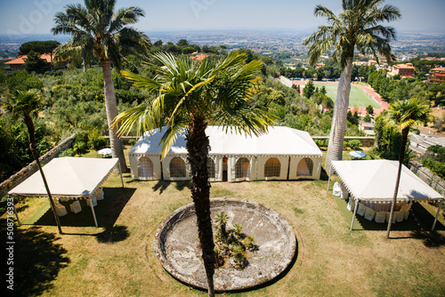 White banquet wedding tent with tall palm trees