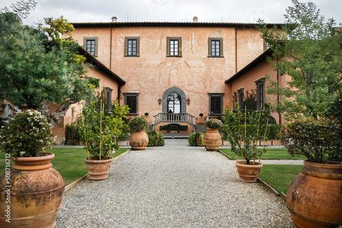 Villa with rows of large pots with trees and flowers