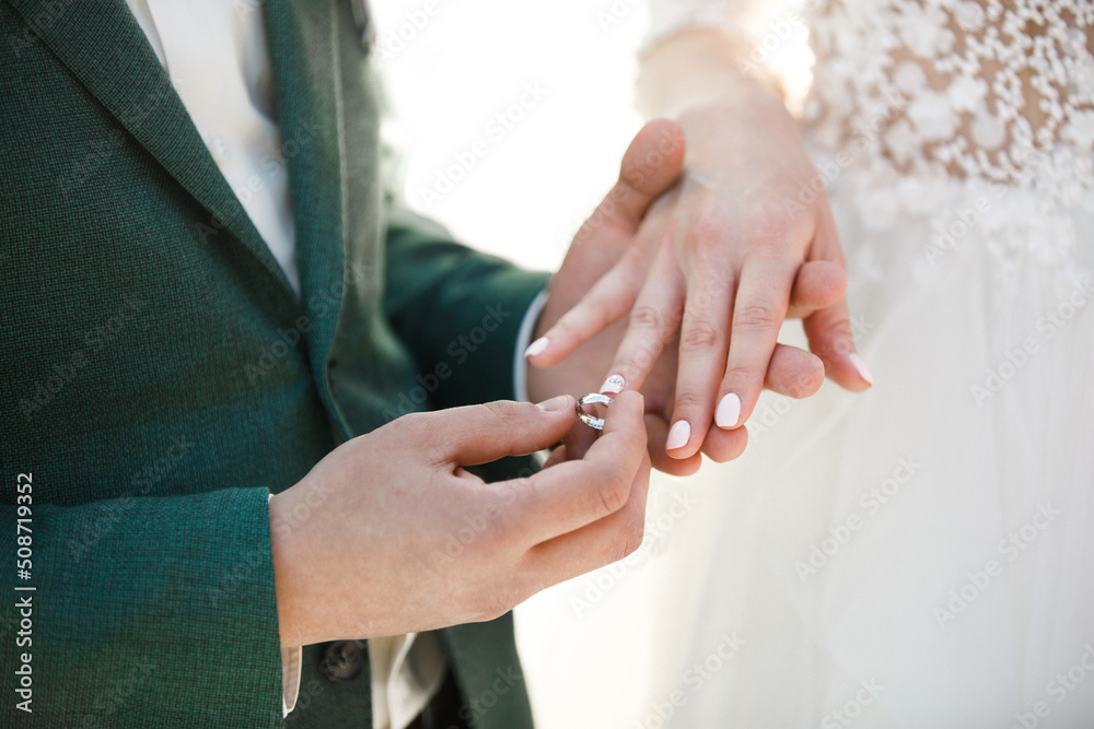 Groom wears ring on bride's finger