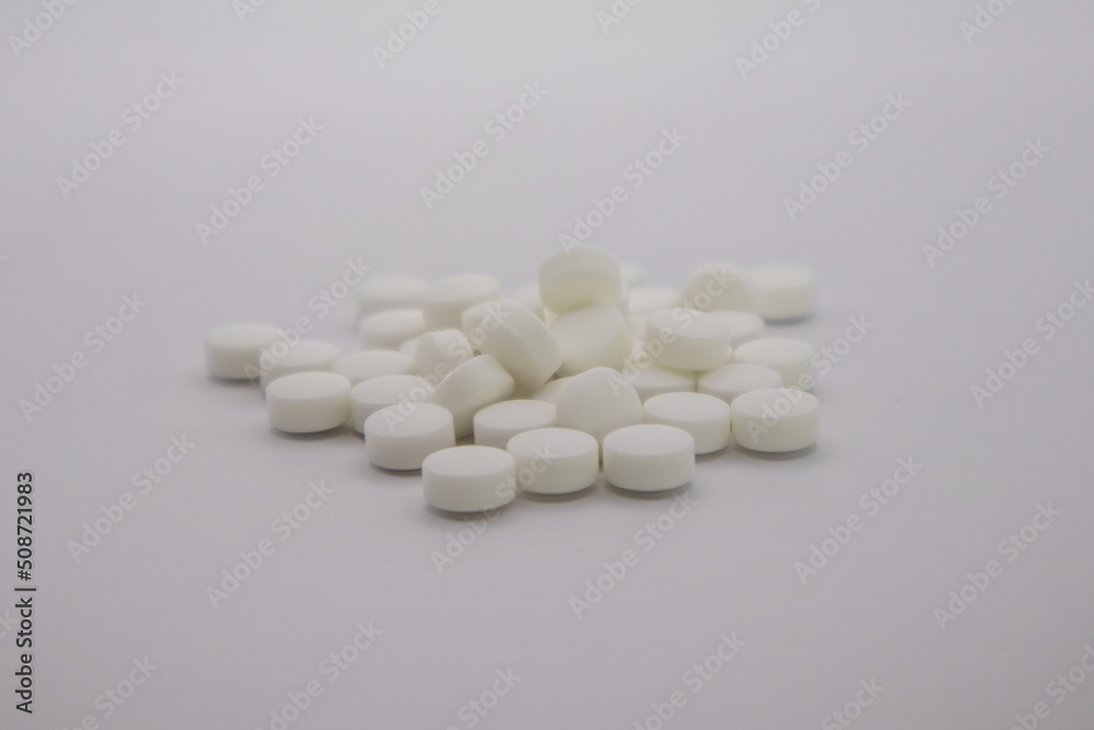 Pile of white pills on neutral background. Bupropion. 