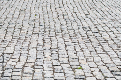 The road is paved with granite stones of a square shape as a background