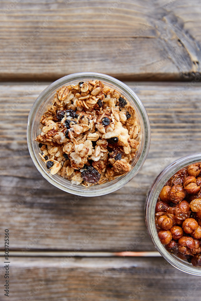 Top view of gronola and roasted chickpeas in jars on a wooden picnic table Top view of gronola and roasted chickpeas in jars on a wooden picnic table