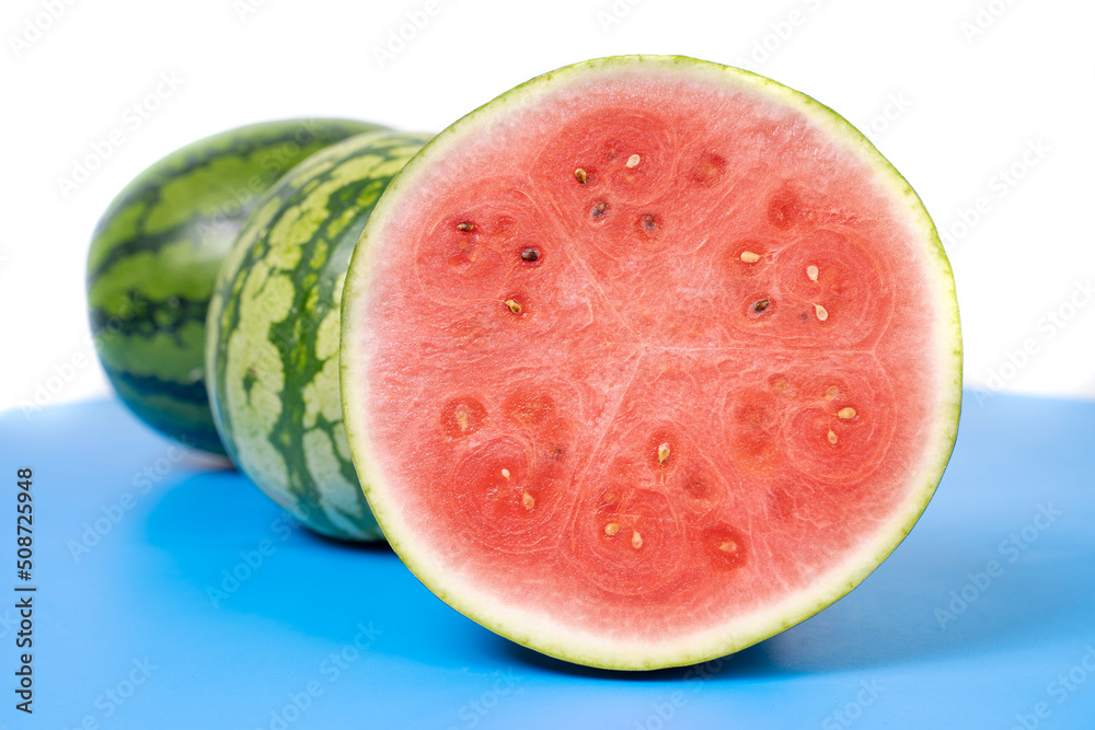 Fresh watermelon cut in half. 
Watermelons with green skin colour and red flesh inside on a white background.