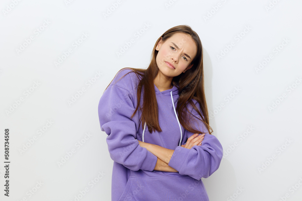 a beautiful woman stands on a white background in a purple tracksuit seriously looking forward crossed her arms in front of her a beautiful woman stands on a white background in a purple tracksuit seriously looking forward crossed her arms in front of her