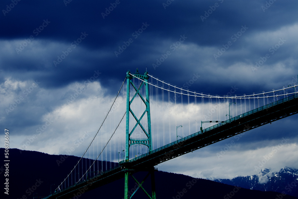 Fototapeta premium Lions Gate Bridge - suspension bridge between Stanley park and north Vancouver in British Columbia with dramatic clouds in the background