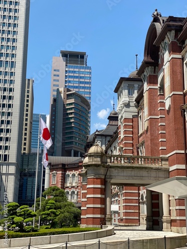 Canvas Print The Japanese country flag outside of the Tokyo Station building, red brick archi