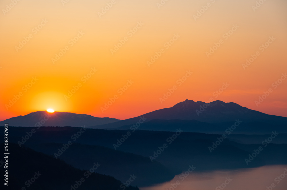 夜明けの空に朝日の輝く瞬間。日本の北海道の美幌峠。