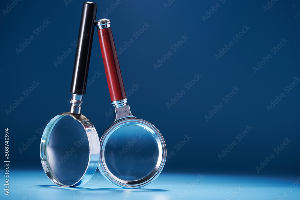 two magnifying glass against blue background two magnifying glass against blue background