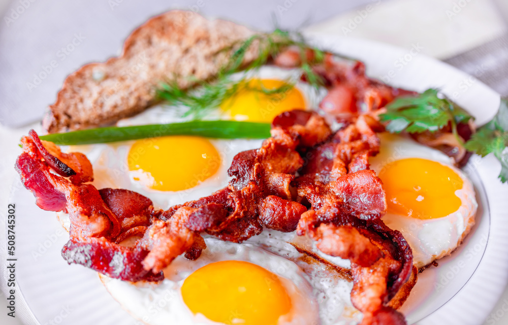 Tasty fried eggs eggs and crispy bacon, close-up, great classic breakfast. Macro photography, shallow depth of field. Tasty fried eggs eggs and crispy bacon, close-up, great classic breakfast. Macro photography, shallow depth of field.