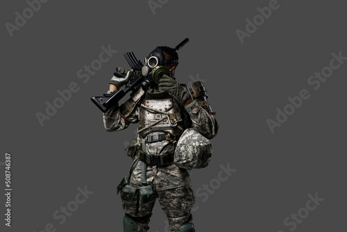 Studio shot of black army soldier dressed in protective gas mask and camouflage clothes.