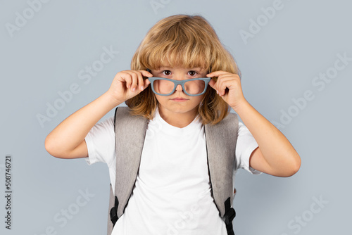 Back to school. Schoolboy with school bag hold book and copybook ready to learn. School children on isolated studio background. Surprised amazed emotions of school boy.