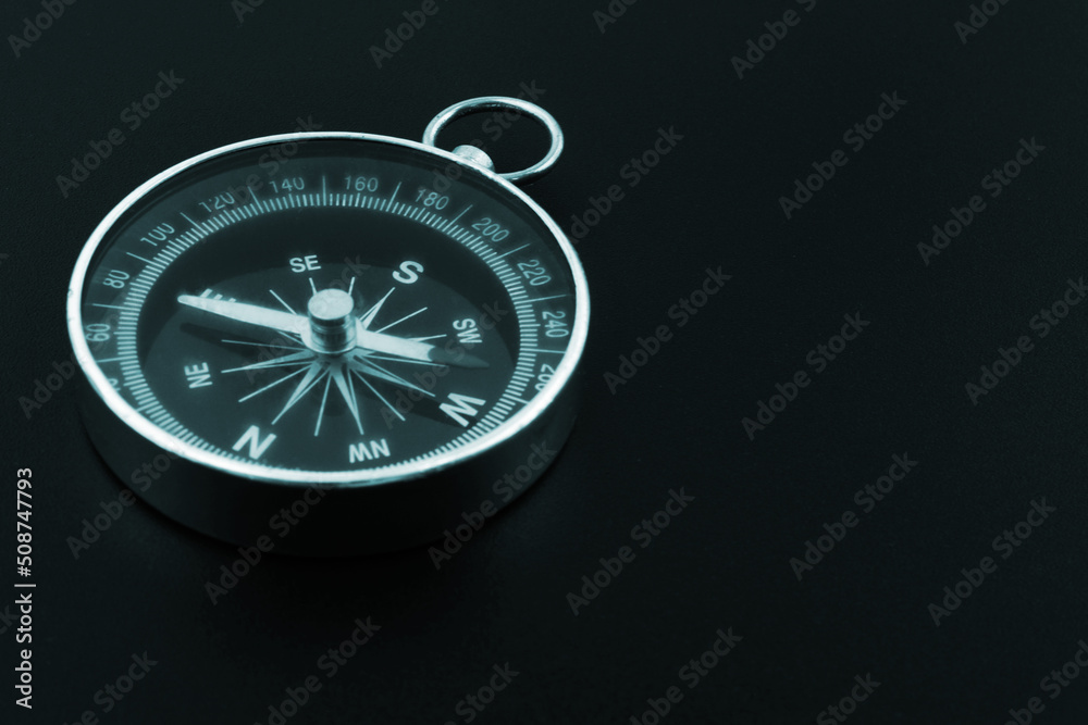 Round compass on black background close-up. Travel, find destination and navigation concept.