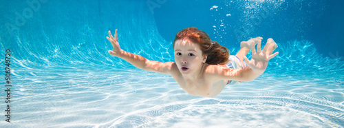 Photo Happy kid swims in pool underwater, active kid swimming under water, playing and having fun, Children water sport