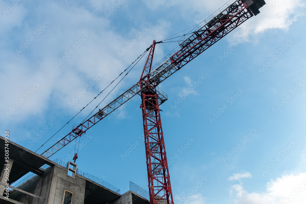 Construction crane against the blue sky. The concept of building a new area. Construction of a new building.