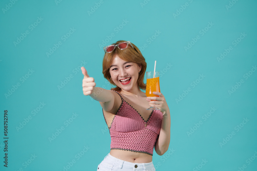 Young beauty in summer Woman with sunglasses drinks orange juice in summer showing thumb up Young beauty in summer Woman with sunglasses drinks orange juice in summer showing thumb up