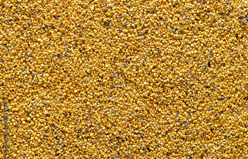 Bee pollen grains, above view. Yellow background with pollen balls.