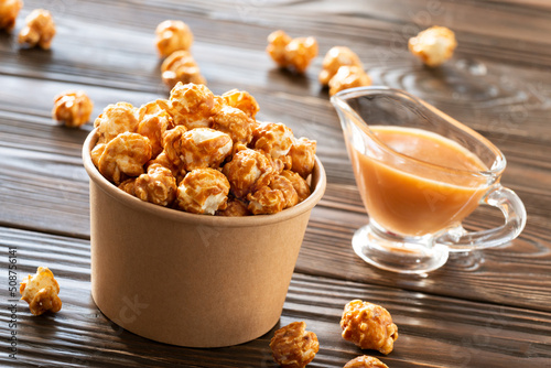 Obraz na płótnie Caramelized popcorn in paper bucket on wooden table w salonie