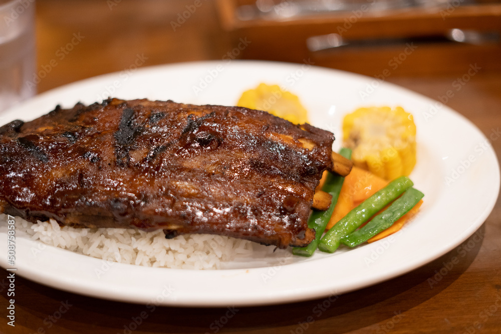 Baby back ribs served with rice sweet corn and vegetables