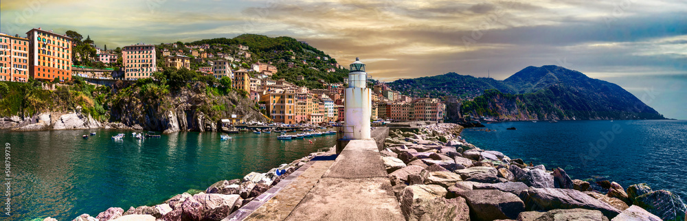 Italy. Camogli - beautiful traditional  village in Liguria, panorama with traditional fishing boats and lighthouse . popular tourist destination 