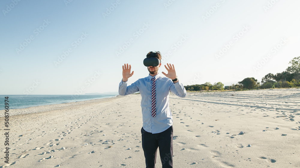 Boy with blue shirt does the metaverse experience on the beach in Summer Boy with blue shirt does the metaverse experience on the beach in Summer