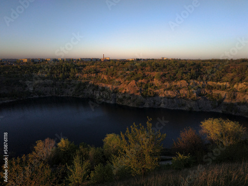 Evening landscape overlooking a flooded quarry in Ukraine. Flooded and abandoned granite quarry