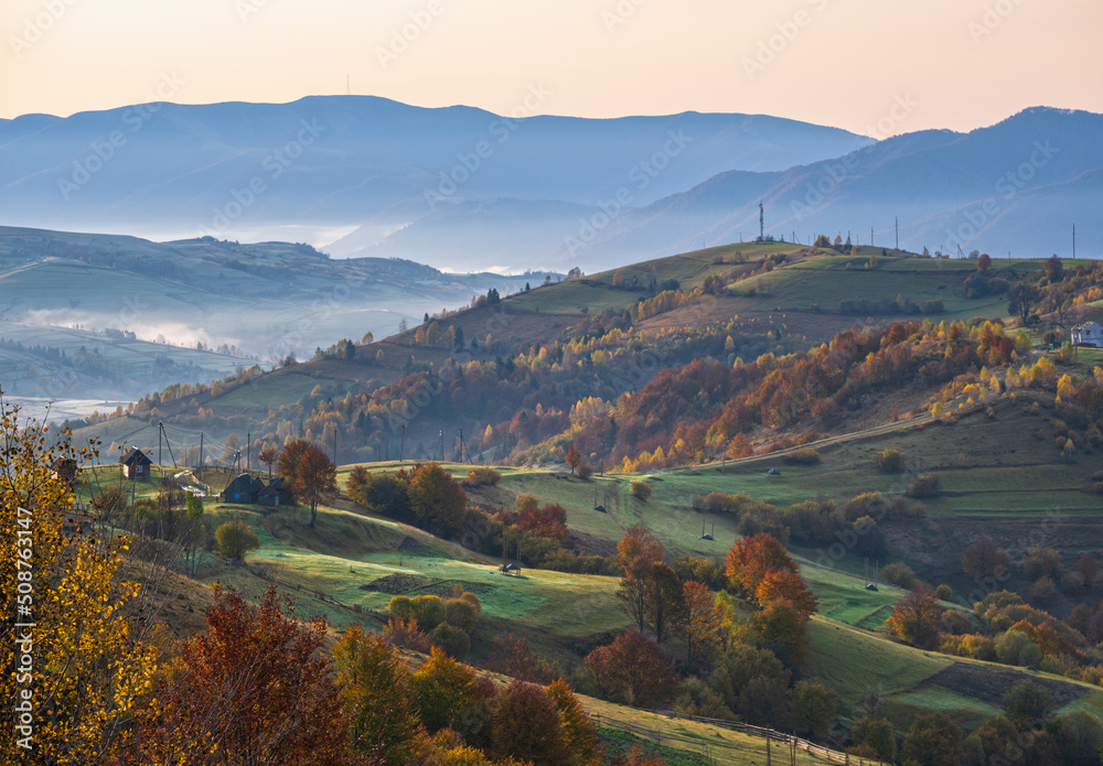 Fototapeta premium Foggy early morning autumn mountains scene. Peaceful picturesque traveling, seasonal, nature and countryside beauty concept scene. Carpathian Mountains, Ukraine.