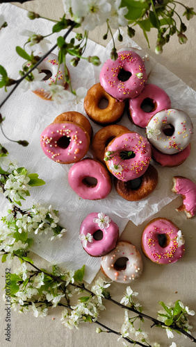 Round donuts in pink and white glaze in flowers. 
cake with flowers.
