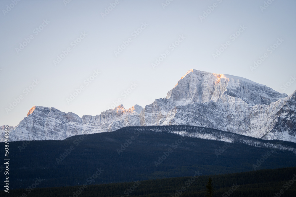 Fototapeta premium Mountain range catching first sun rays on a cold winter morning, Banff N. Park, Canada