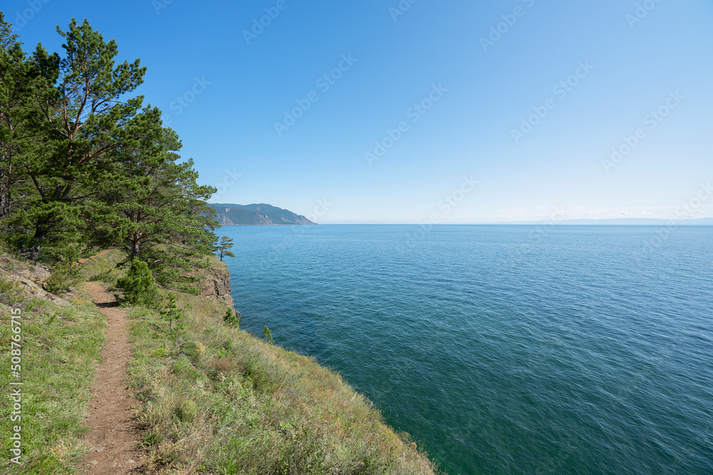 Lake Baikal coast, hill with forest, water bay. Summer travel, discovery of beauty of Earth. Siberia, Russia.