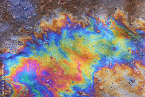 puddle gasoline background, wet oil multicolored rainbow pollution spill