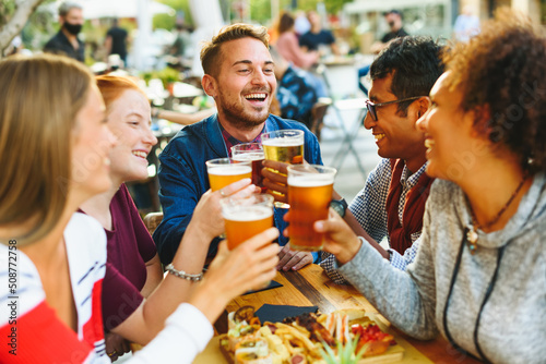 Cheerful multiethnic friends clinking glasses of beer