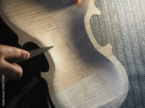 Obraz na plátně luthier sawing the back belly plate outline of a new handmade violin from above