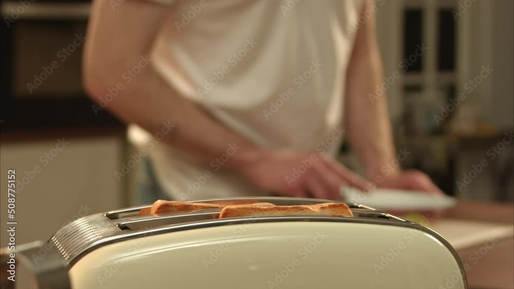 hot toast bread is jumping from the toaster. man cook his own breakfast with sandwiches. man preparing food for his wife. fresh crispy bread. 100fps 2.8k hot toast bread is jumping from the toaster. man cook his own breakfast with sandwiches. man preparing food for his wife. fresh crispy bread. 100fps 2.8k