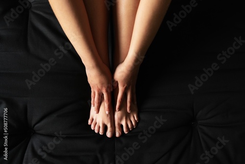 Closeup of bare legs of a woman against dark background