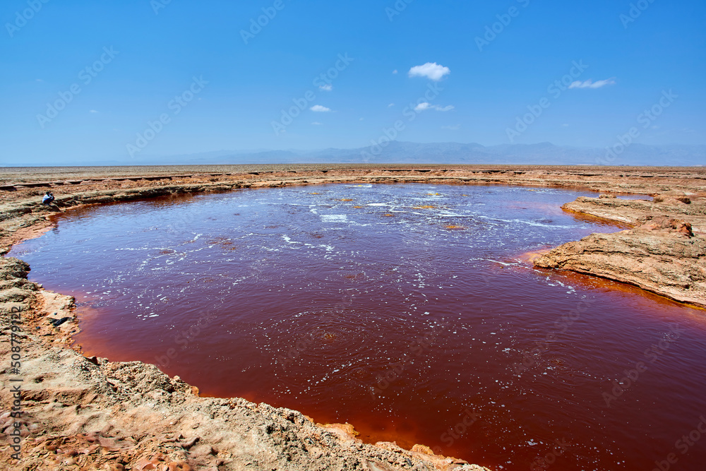 Reddish-brown lake with salt water containing tar near the Dallol Volcano in the Danakil Desert, Ethiopia
