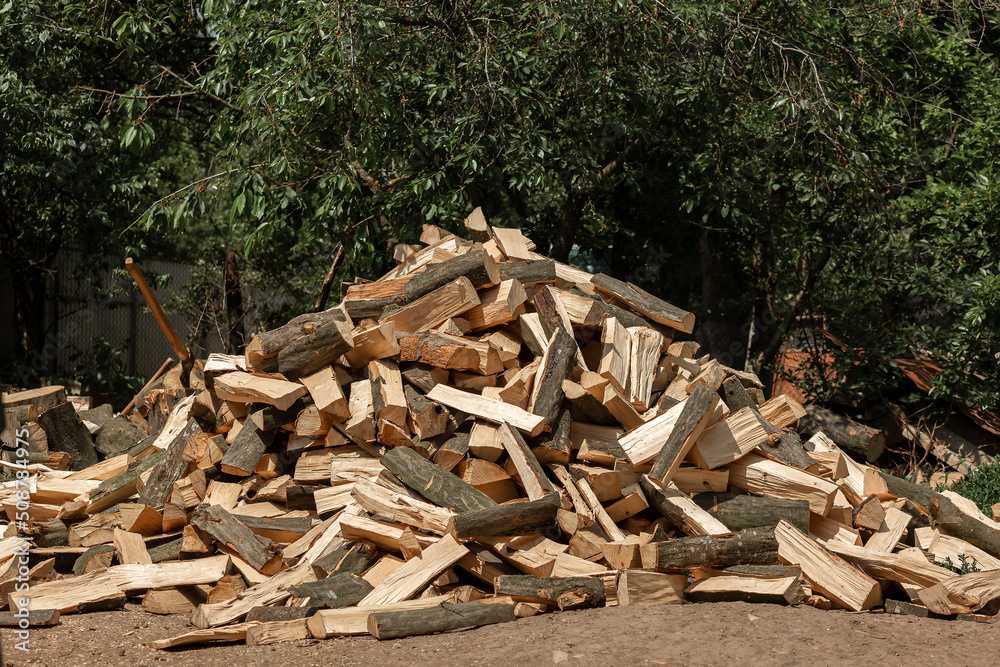 Firewood chopped with an ax for the stove lies in a heap in the yard. Chopped glades Firewood chopped with an ax for the stove lies in a heap in the yard. Chopped glades