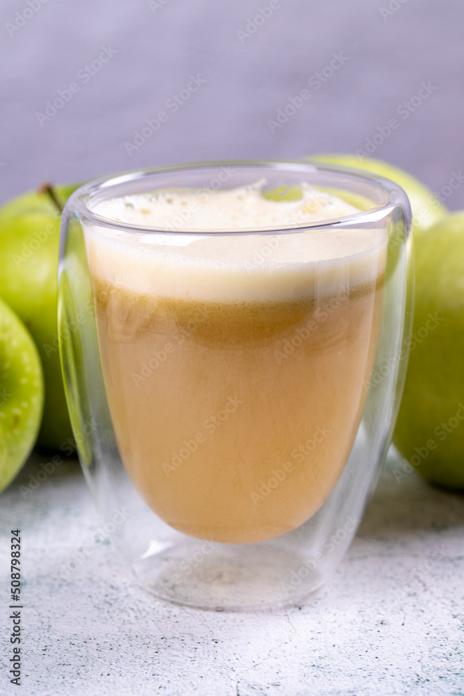 Apple juice. Freshly squeezed juice. Freshly squeezed apple juice in glass on stone background. Close-up Apple juice. Freshly squeezed juice. Freshly squeezed apple juice in glass on stone background. Close-up